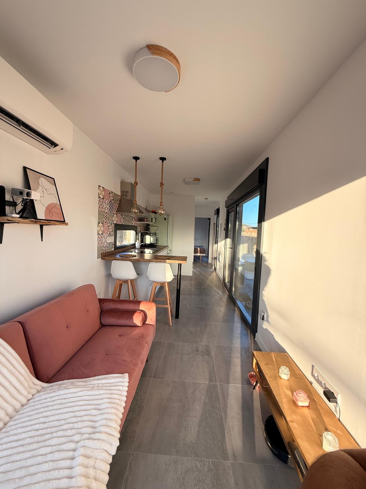 Salón interior de la casa rural contenedor Los Almendros con sofá y cocina