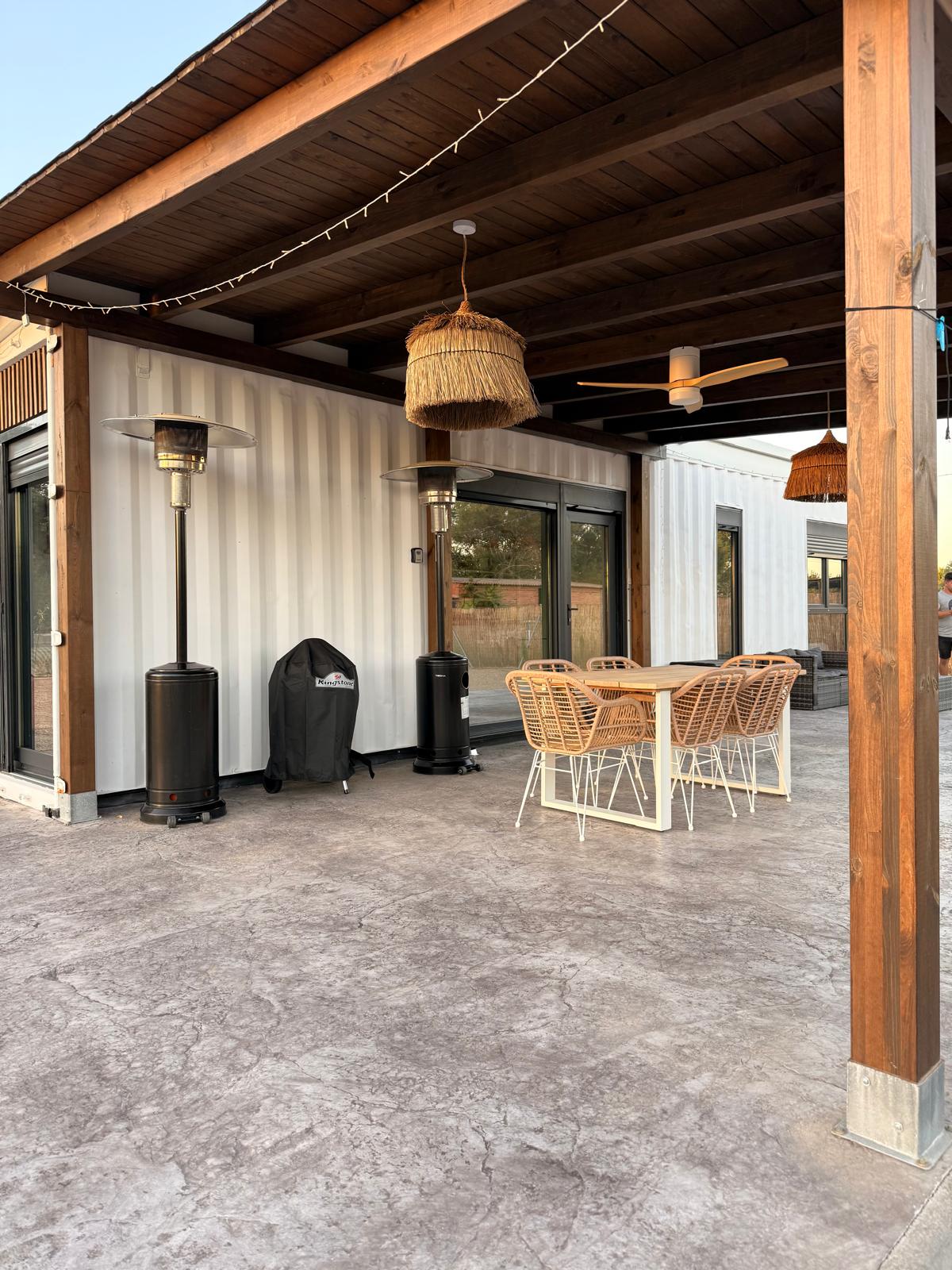 Terraza cubierta con vigas de madera de la casa contenedor Los Almendros
